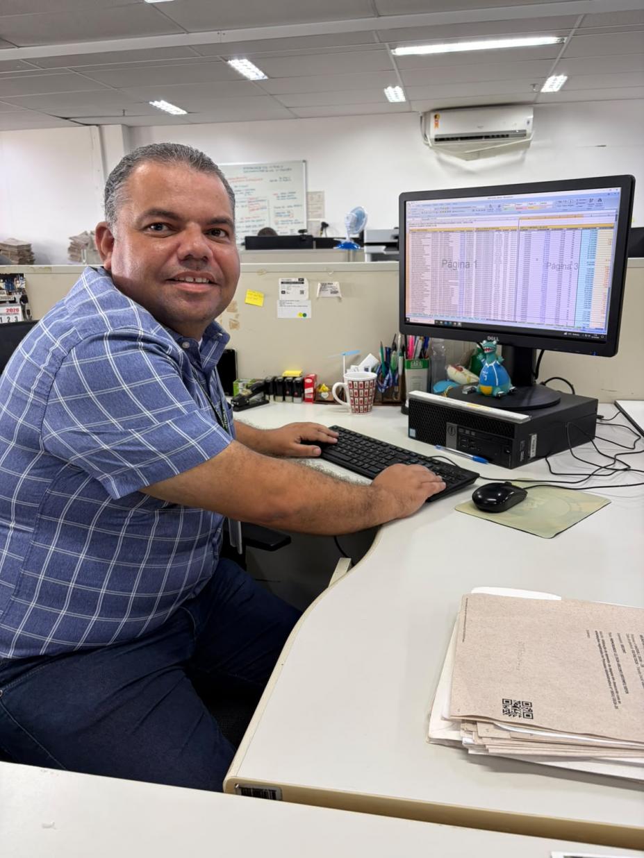 Servidor olha para a câmera sentado no computador #paratodosverem 