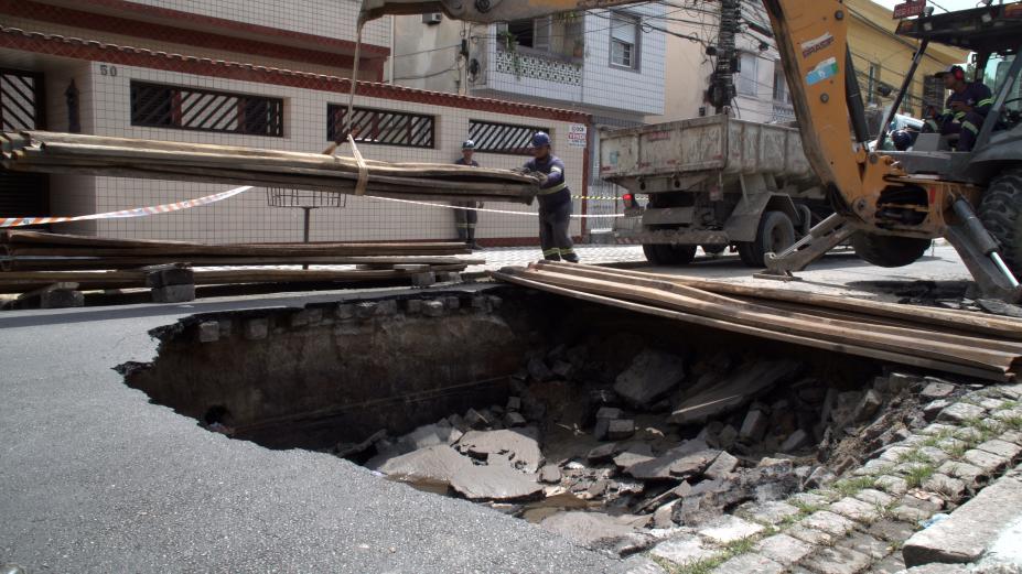 trator carrega placas de madeira para cobrir trecho. #paratodosverem