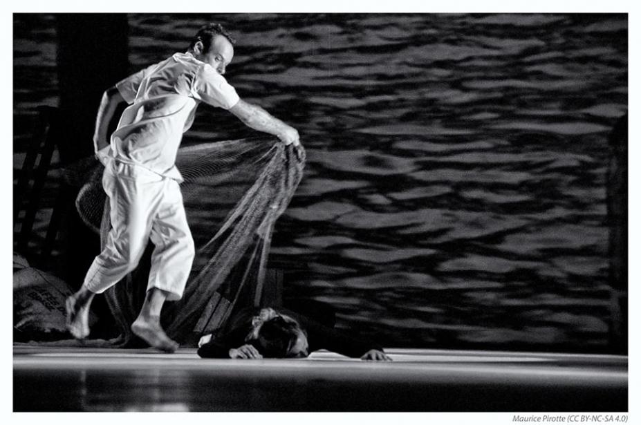 cena de homem cobrindo o corpo de um homem no chão com uma espécie de rede ou véu