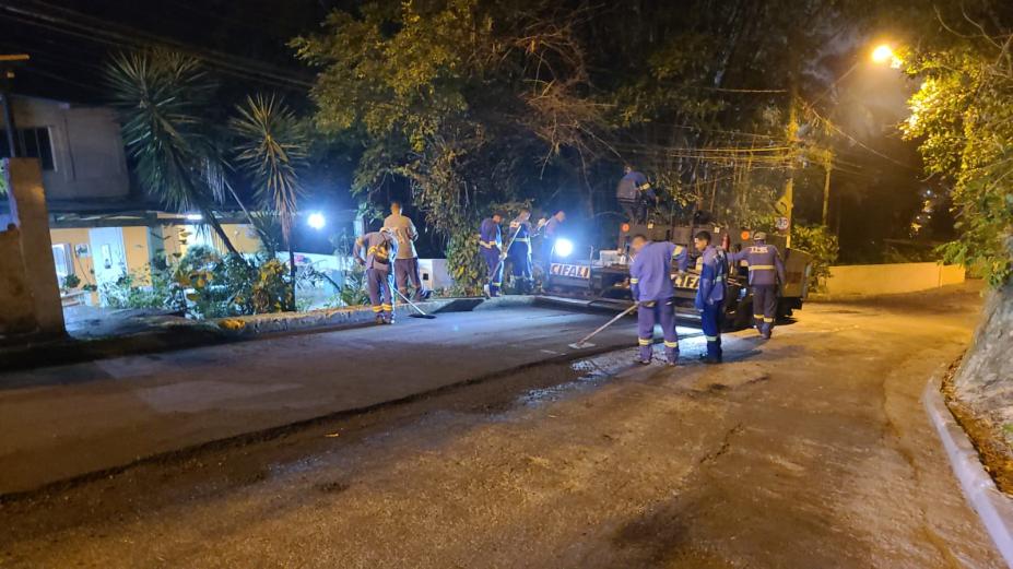 homens estão pavimentando rua à noite. #paratodosverem