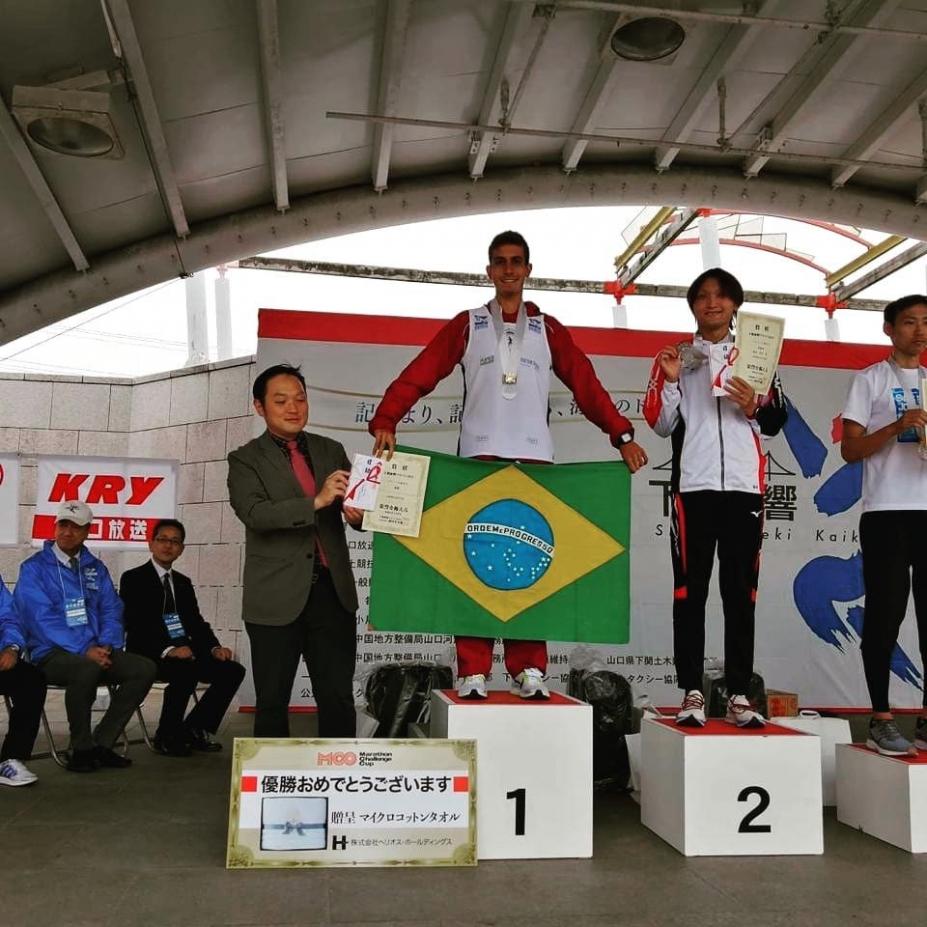 João mostra bandeira do Brasil no alto do pódio. #pracegover