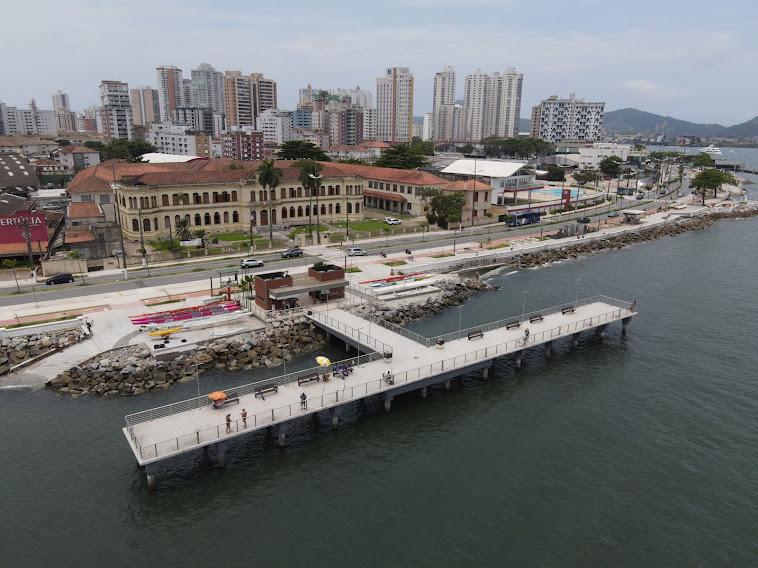 vista aérea do deck do pescador, com o mar à frente e prédios ao fundo. #paratodosverem 