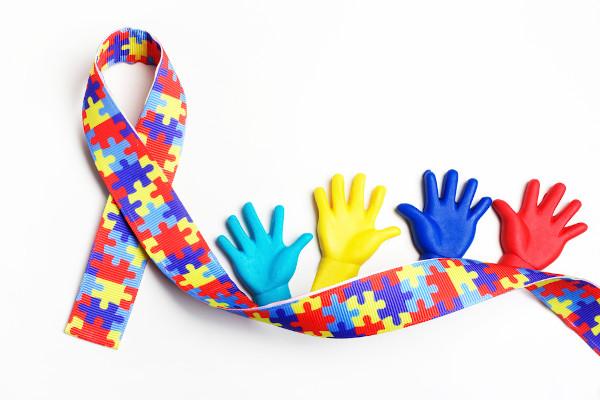 laço do autismo com quatro mãozinhas coloridas ao lado direito. #paratodosverem