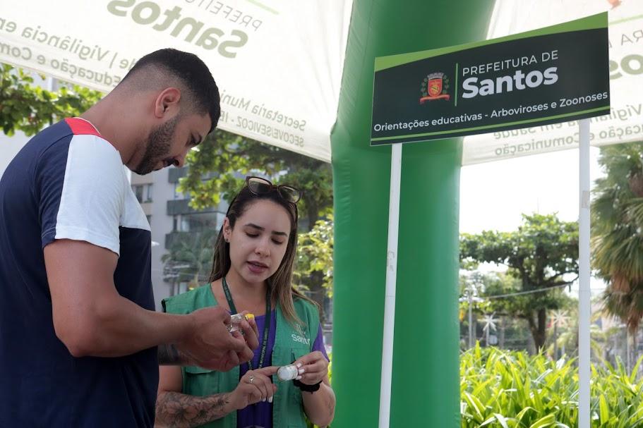 mulher orienta homem em estande educativo #paratodosverem 