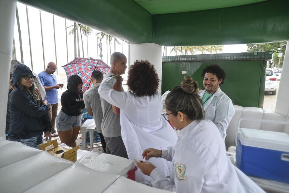pessoas sendo vacinadas em estande da saúde #paratodosverem