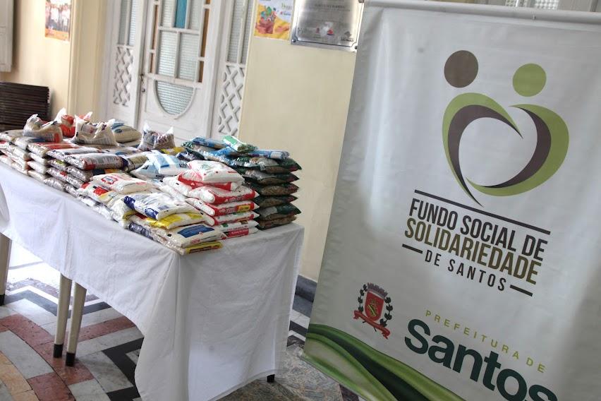 vários alimentos dispostos sobre uma mesa e o banner do fundo social ao lado.  #paratodosverem