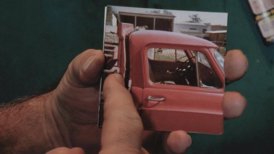 Mão segurando fotografia de caminhão. #pracegover