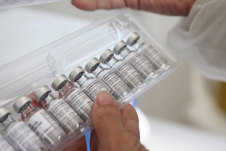 close de doses de vacinas em uma caixa transparente na mão de uma pessoa. #paratodosverem