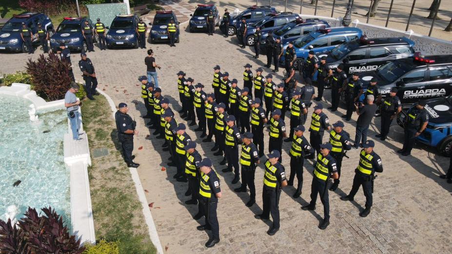 guardas municipais e viaturas perfilados em praça ao ar livre. #paratodosverem