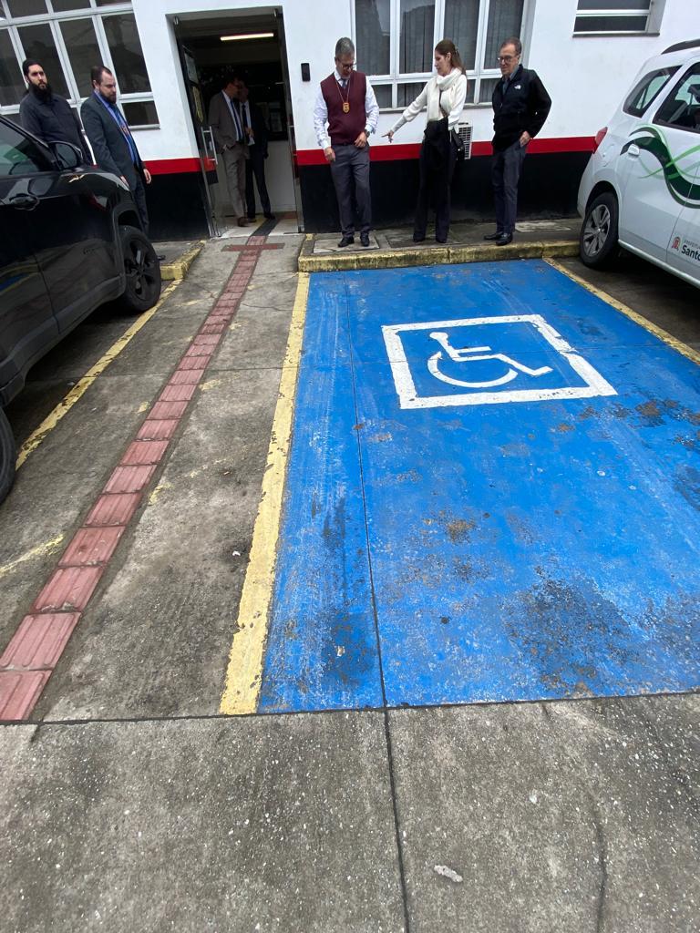 Vaga para estacionamento de veículos de pessoas com deficiências e pessoas ao fundo. #paratodosverem