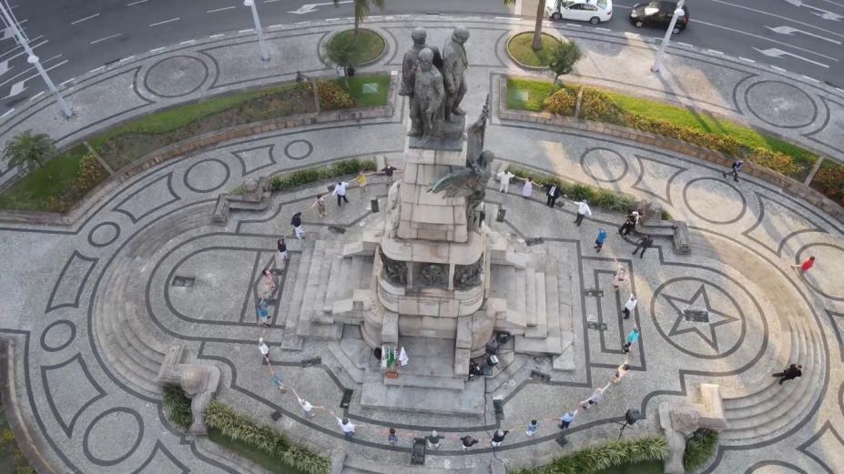 vista da praça da independência do alto, feita com drone. Pessoas estão em torno do movimento abraçando-o