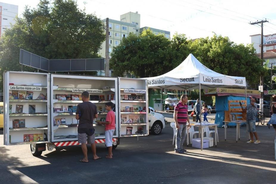 biblioteca móvel parada em praça com pessoas escolhendo livros - foto: arquivo/PMS