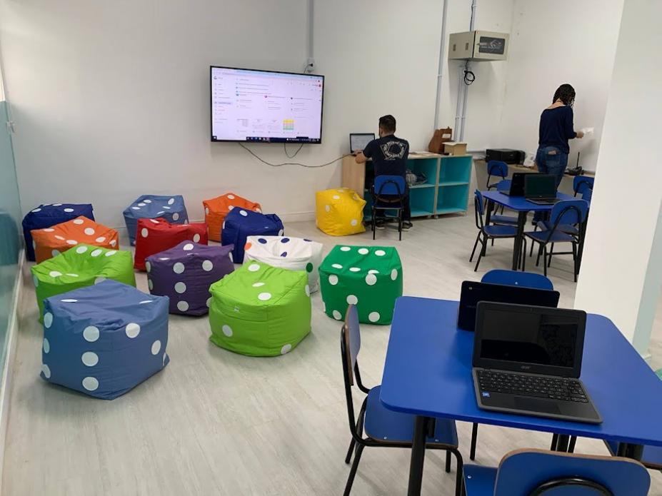 Estudioteca com mesas, cadeiras e computadores #paratodosverem