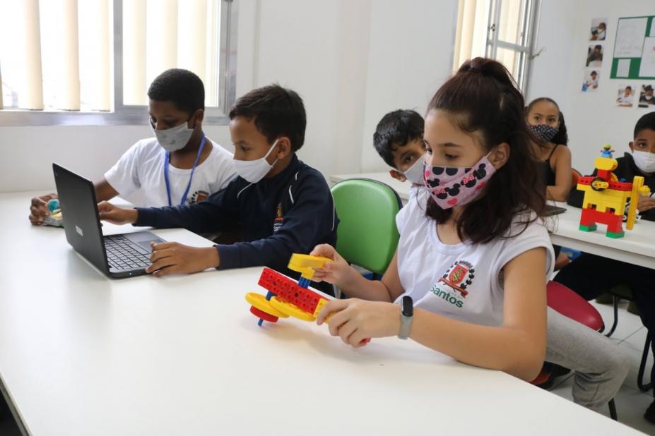 Alunos participam de aula de informática e robótica. #paratodosverem