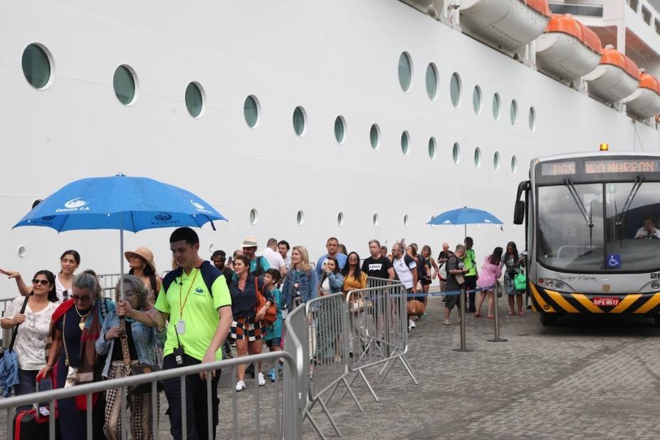 fila de passageiros para ingressar em navio atracado no porto. #paratodosverem 