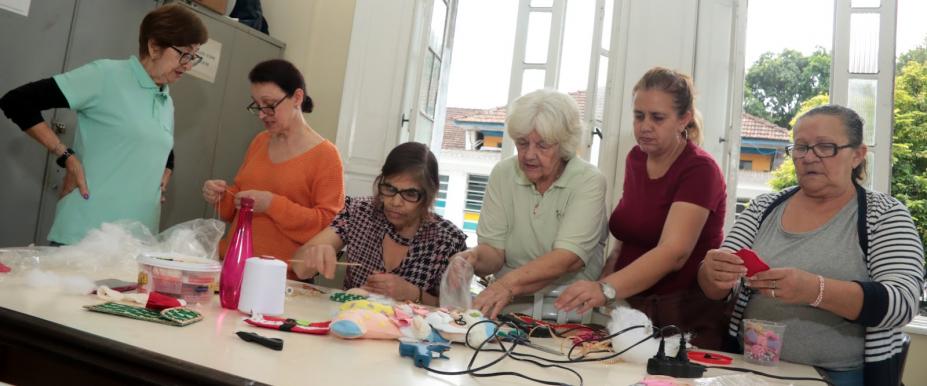 pessoas fazendo enfeites de Natal #paratodosverem 
