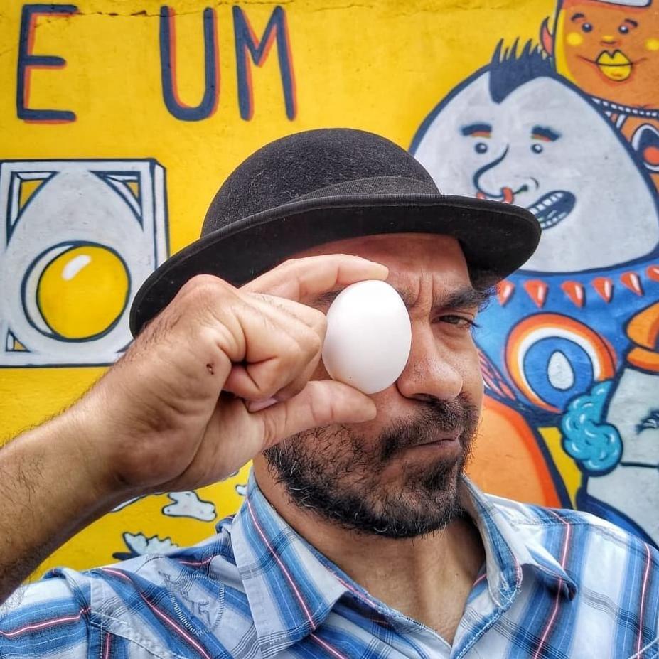 Artista posa para foto com um ovo na frente do olho #paratodosverem