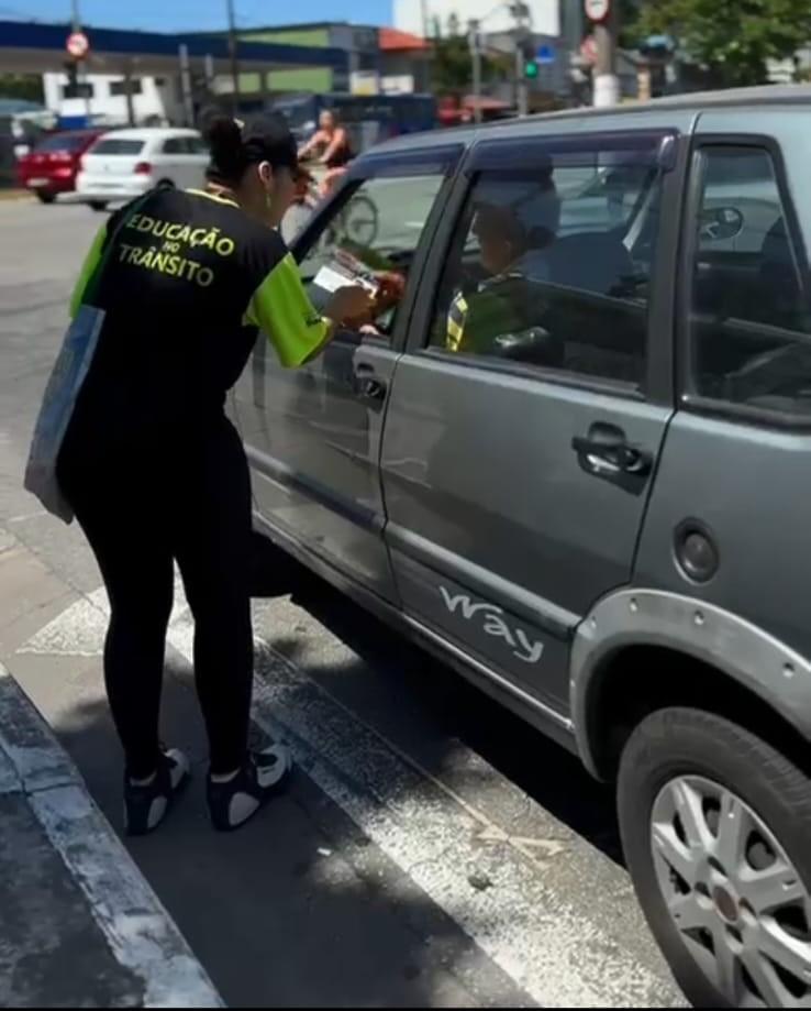 agente entrega panfleto a motorista #paratodosverem