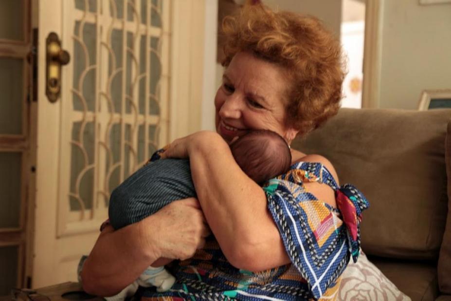 Mulher abraça criança no colo #paratodosverem