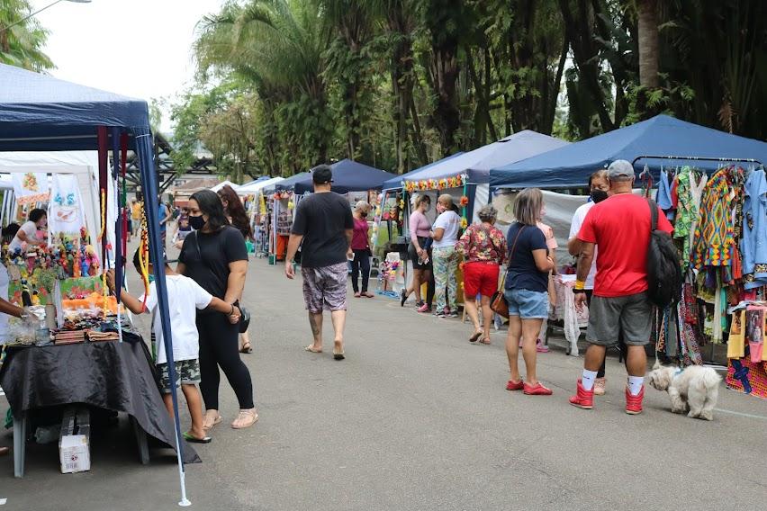 Várias pessoas passando entre barracas da feira #paratodosverem