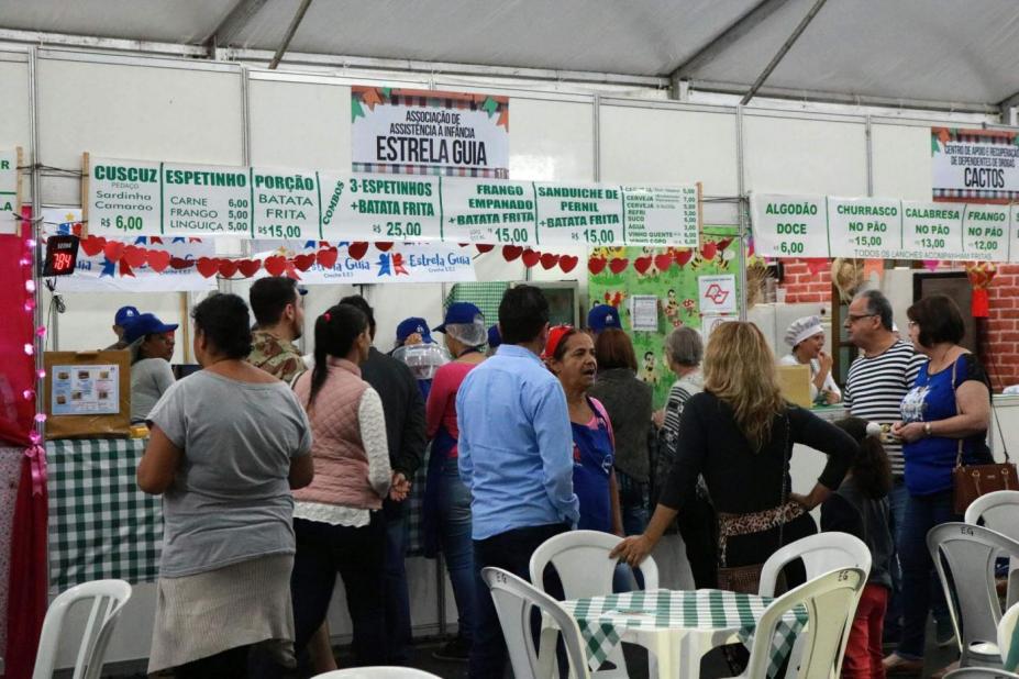 barracas de lanches e salão de refeições com pessoas circulando. #paratodosverem 