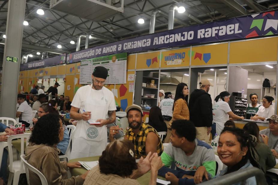 pessoas comendo na festa inverno #paratodosverem