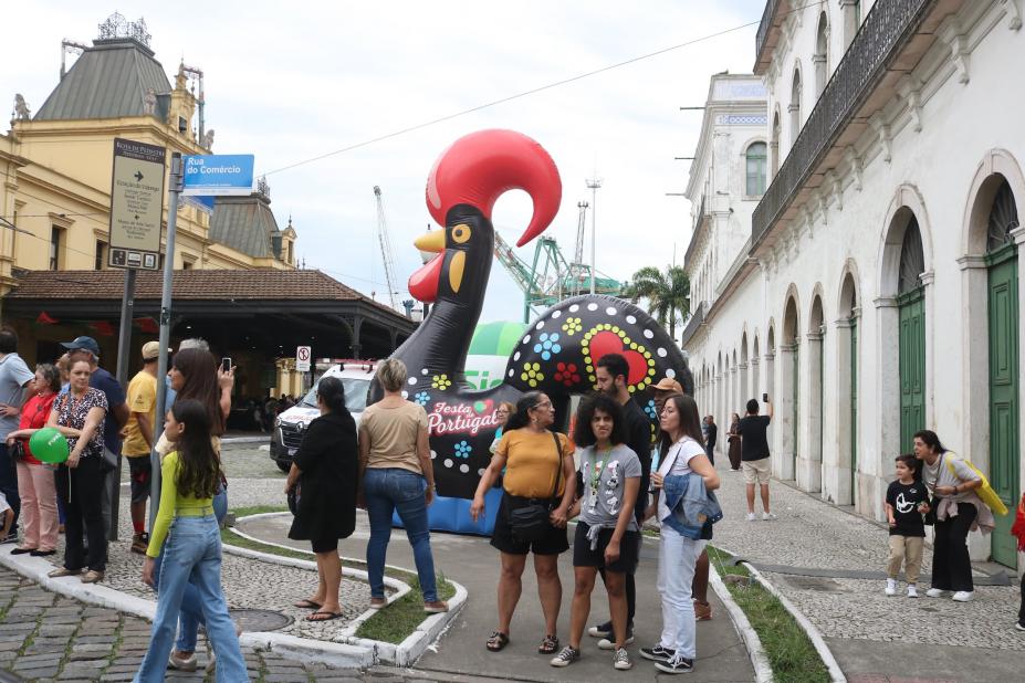 grande galo português ao fundo com turistas em torno. #paratodosverem