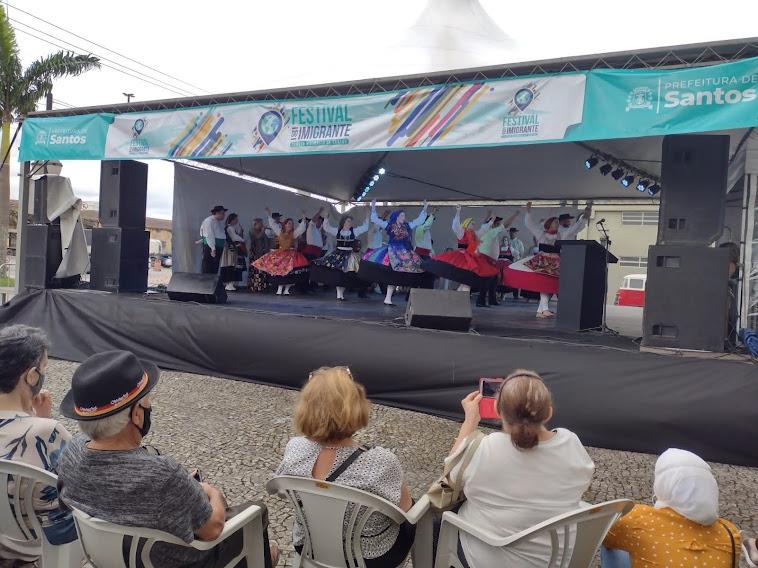 Público assiste apresentação de dança folclórica portuguesa em palco no Valongo. #pracegover