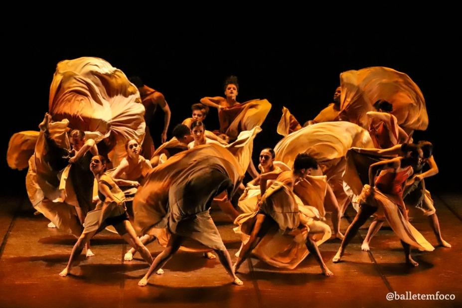 bailarinos dança em palco. Eles movimentam suas saias com velocidade. #paratodosverem 