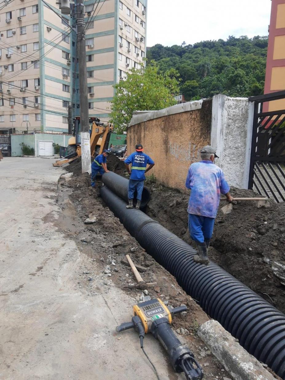 tubo aparente na lateral de rua com homens trabalhando. #paratodosverem 