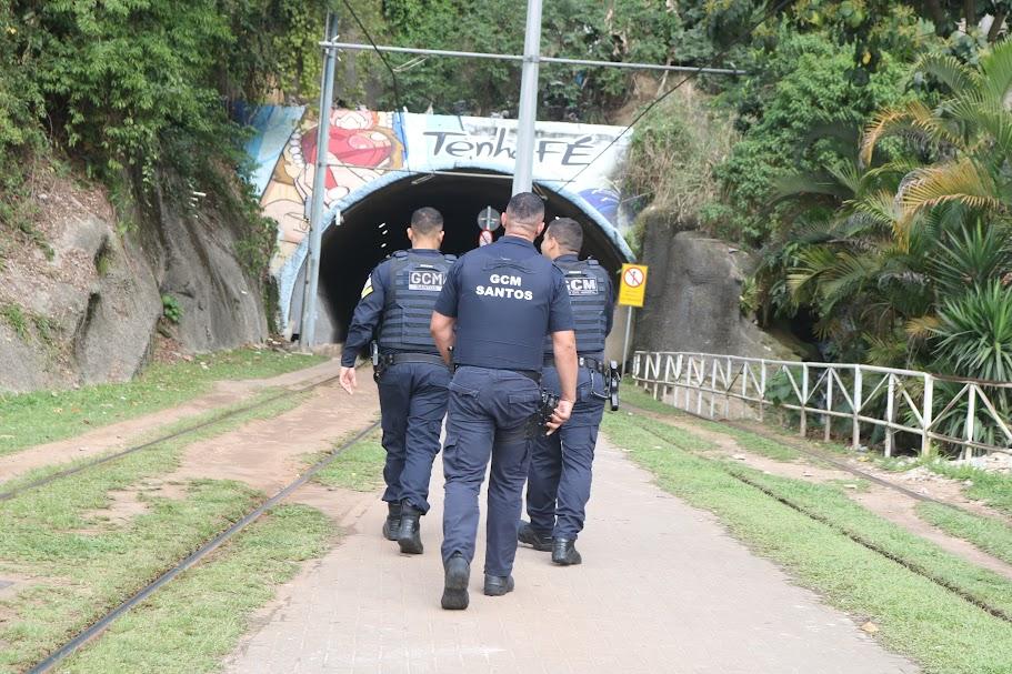 homens de costa andando em direção a túnel #paratodosverem