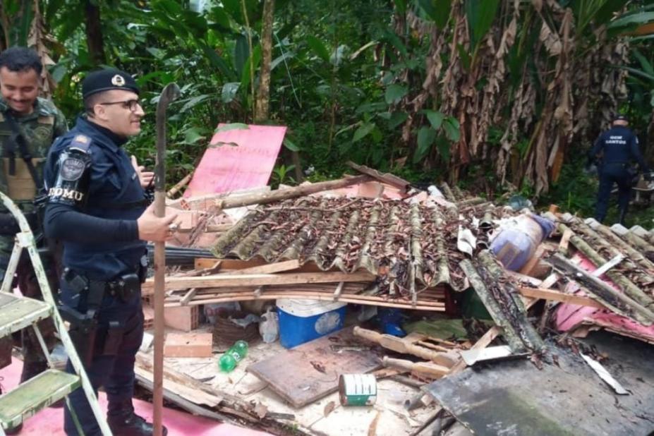 guarda municipal está em  pé diante de esconderijo destruído no meio do mato. #paratodosverem