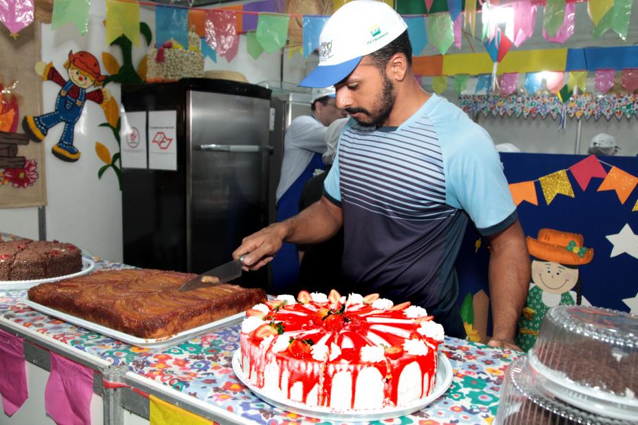 voluntário corta bolo em barraca #pracegover 