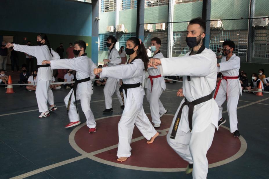 pessoas com uniforme de caratê fazendo exercícios #paratodosverem
