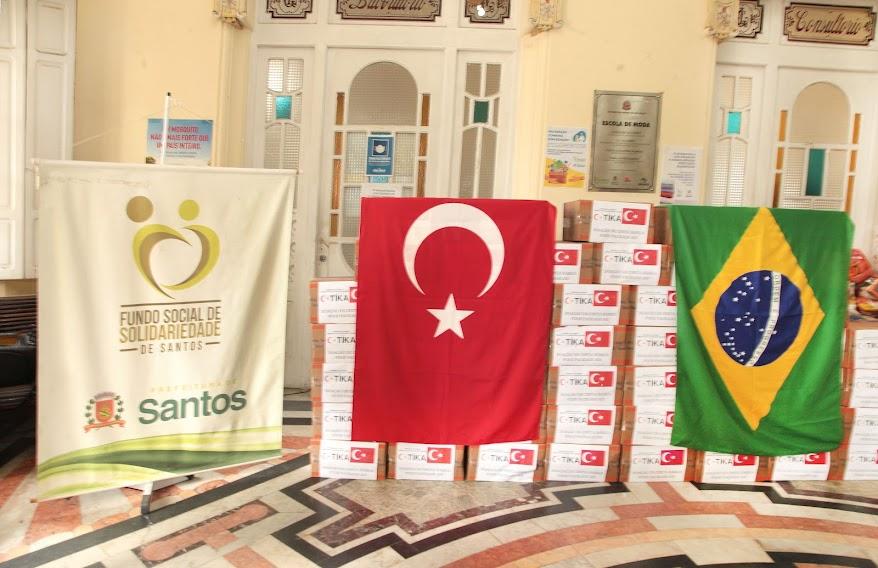Caixas de cestas básicas com a bandeira da Turquia e do Brasil em cima. #paratodosverem