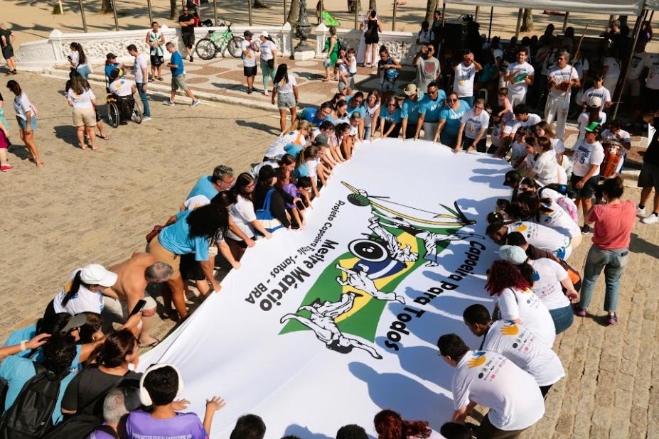 pessoas estendem grande faixa #paratodosverem