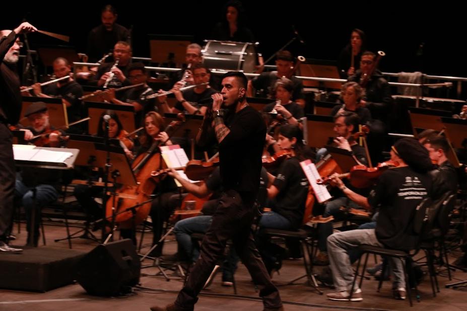 Cantor e orquestra ao fundo #paratodosverem