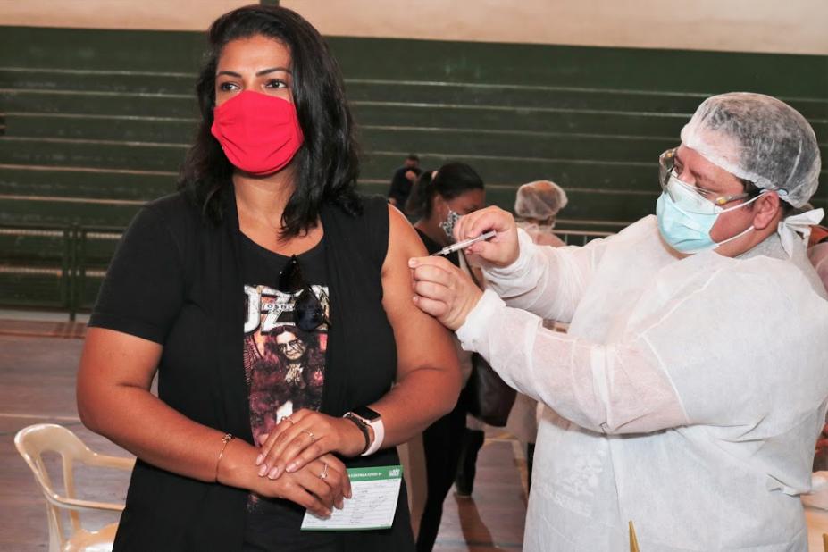 Mulher recebe aplicação na vacina de enfermeiro. #paratodosverem