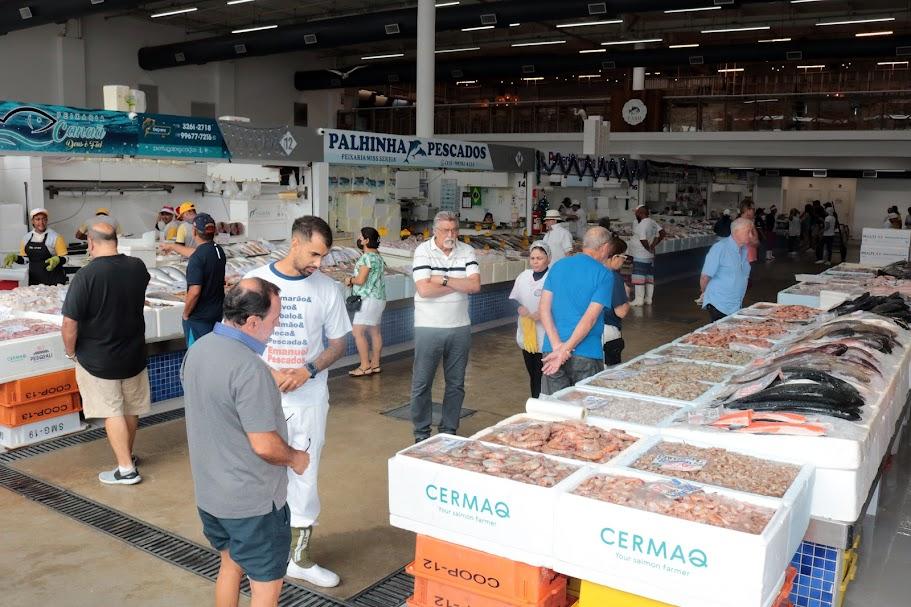 boxes com exposição de peixes e pessoas circulando. #paratodosverem