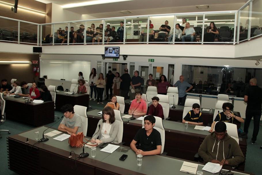 jovens estão sentados em tribuna da câmara municipal. #paratodosverem 