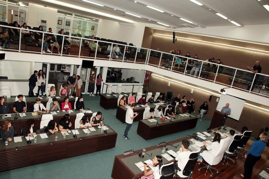 jovens estão sentados no plenário da Câmara municipal. #paratodosverem