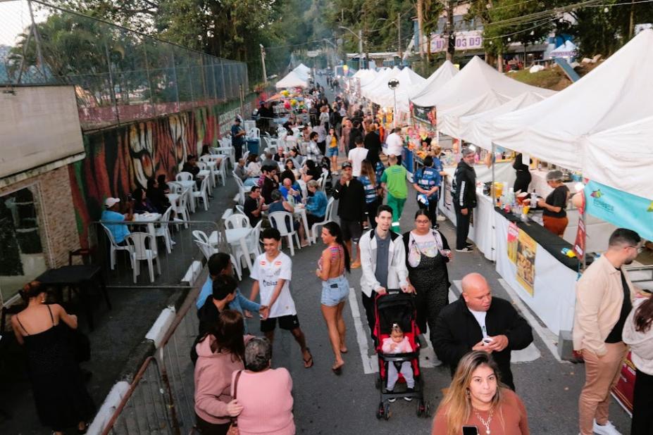 pessoas circulando perto de barracas de evento #paratodosverem