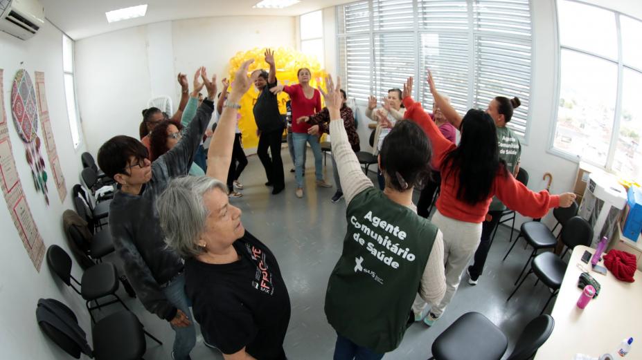 mulheres em roda com braços estendidos em exercício. #paratodosverem