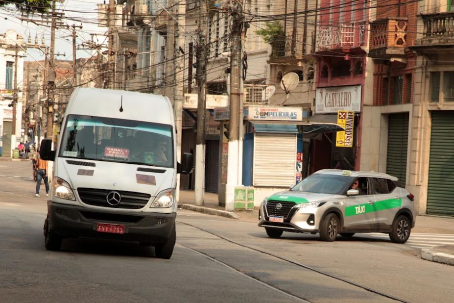 van de lotação e táxi na rua. #paratodosverem