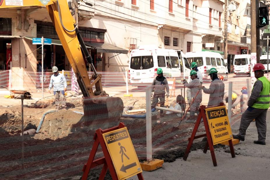 rua interditada e com obras. Há máquinas operando e homens trabalhando na pista. #paratodosverem 