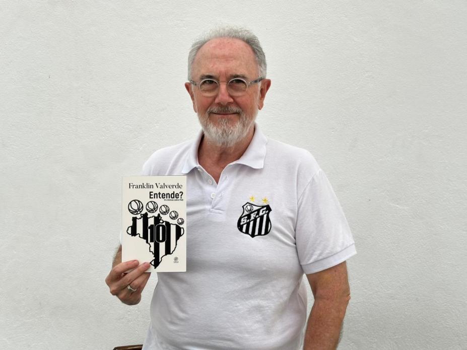 Autor mostra o livro. #Paratodosverem.