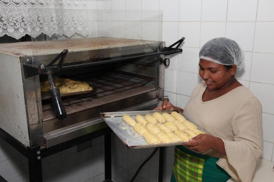 mulher olha pães retirados de forno #paratodosverem