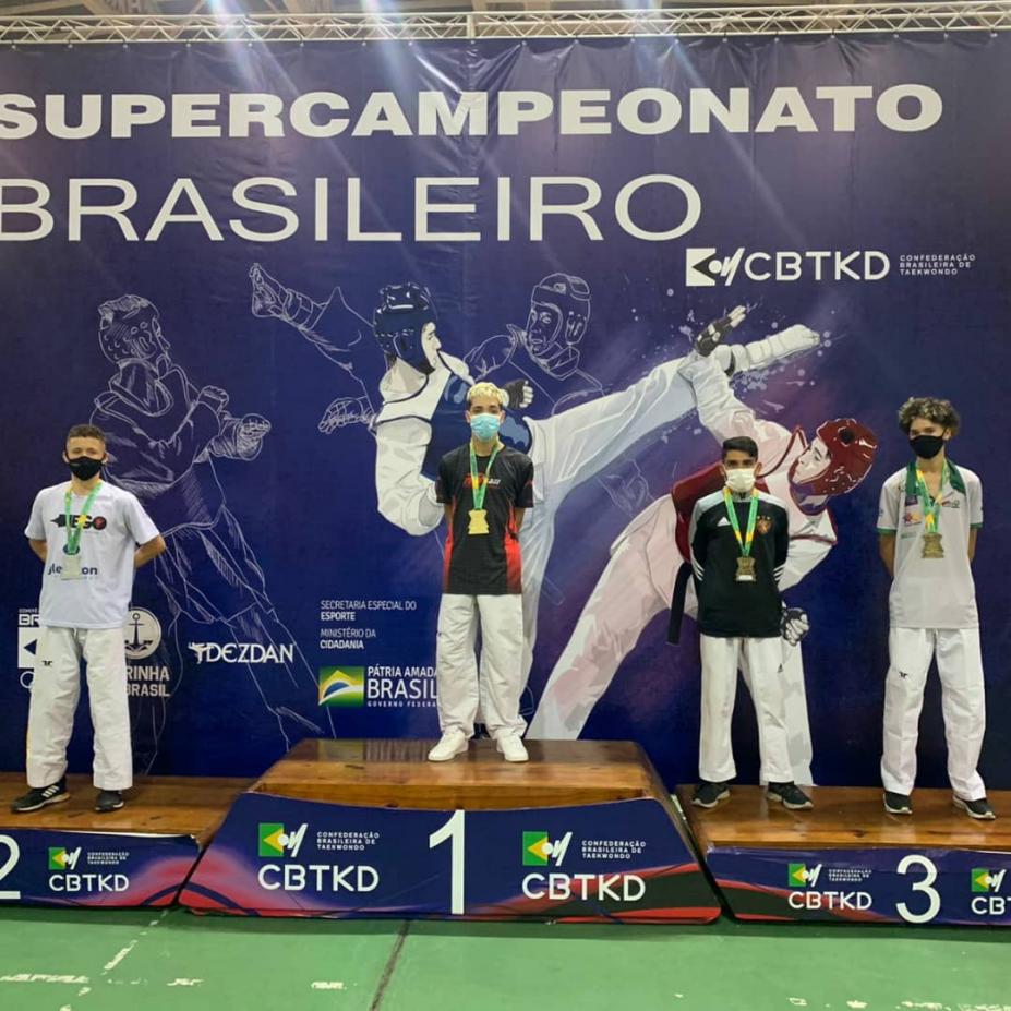 Atletas no pódio com medalha #paratodosverem