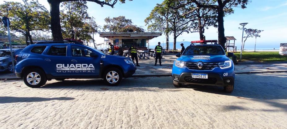 viaturas da guarda municipal estão na orla, próximas a quiosque. #paratodosverem