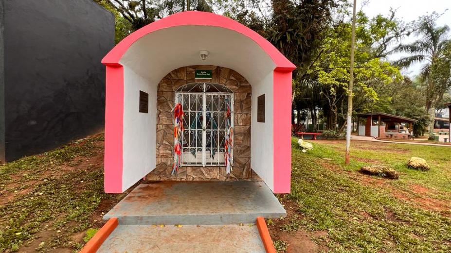 a gruta de santa sara pintada de rsa. Há gramado em torno. #paratodosverem